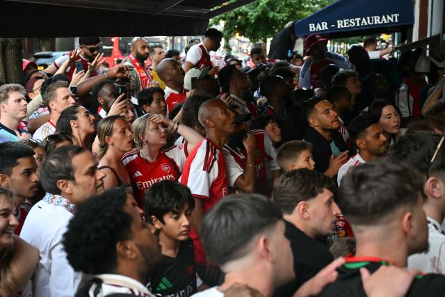 Arsenal fans react as they watch the penalty shoot-out near to Arsenal's ground during the UEFA Champions League Final against Paris Saint-Germain, in London on May 30, 2026. (Photo by JUSTIN TALLIS / AFP)
