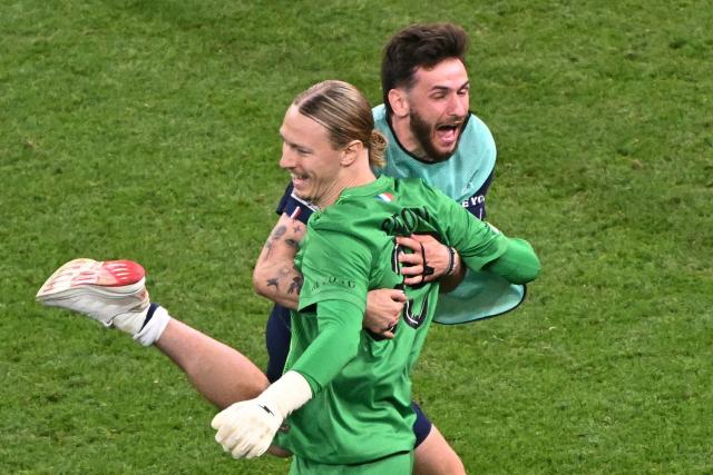 Paris Saint-Germain's Russian goalkeeper #39 Matvey Safonov and Paris Saint-Germain's Georgian forward #07 Khvicha Kvaratskhelia celebrate after winning the UEFA Champions League final football match between Paris Saint-Germain (PSG) and Arsenal FC at the Puskas Arena in Budapest on May 30, 2026. (Photo by Attila KISBENEDEK / AFP)