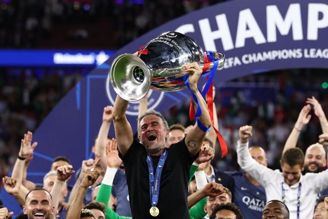 Paris Saint-Germain's Spanish head coach Luis Enrique (C) lifts the trophy as he celebrates with his players after winning the UEFA Champions League final football match between Paris Saint-Germain (PSG) and Arsenal FC at the Puskas Arena in Budapest on May 30, 2026. (Photo by FRANCK FIFE / AFP)