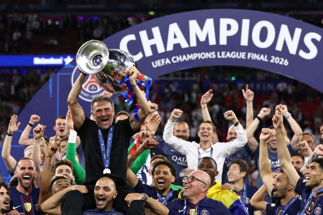 Paris Saint-Germain's Spanish head coach Luis Enrique lifts the trophy as he celebrates with his players after winning the UEFA Champions League final football match between Paris Saint-Germain (PSG) and Arsenal FC at the Puskas Arena in Budapest on May 30, 2026. (Photo by FRANCK FIFE / AFP)