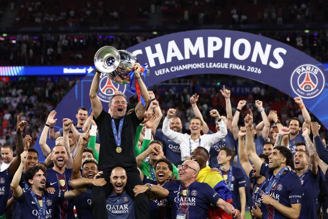 TOPSHOT - Paris Saint-Germain's Spanish head coach Luis Enrique (C) lifts the trophy as he celebrates with his players winning the UEFA Champions League final football match between Paris Saint-Germain (PSG) and Arsenal FC at the Puskas Arena in Budapest on May 30, 2026. (Photo by FRANCK FIFE / AFP)