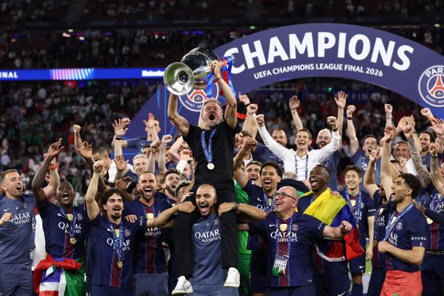 Paris Saint-Germain's Spanish head coach Luis Enrique (C) lifts the trophy as he celebrates with his players after winning the UEFA Champions League final football match between Paris Saint-Germain (PSG) and Arsenal FC at the Puskas Arena in Budapest on May 30, 2026. (Photo by FRANCK FIFE / AFP)