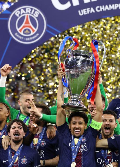 Paris Saint-Germain's Brazilian defender #05 Marquinhos (C) lifts the trophy as he celebrates with teammates after winning the UEFA Champions League final football match between Paris Saint-Germain (PSG) and Arsenal FC at the Puskas Arena in Budapest on May 30, 2026. (Photo by FRANCK FIFE / AFP)