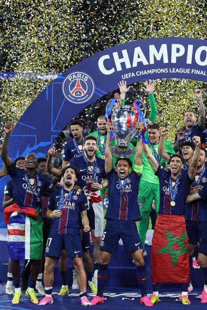 Paris Saint-Germain's Brazilian defender #05 Marquinhos (C) lifts the trophy as he celebrates with teammates winning the UEFA Champions League final football match between Paris Saint-Germain (PSG) and Arsenal FC at the Puskas Arena in Budapest on May 30, 2026. (Photo by FRANCK FIFE / AFP)
