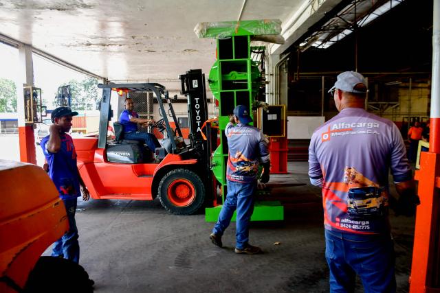 Workers move machinery for a new production line at the Caucho Industrial Park --former US Goodyear plant-- in Los Guayos municipality, Carabobo state, Venezuela, on May 30, 2026. After seven years of inactivity, the former Goodyear tyre plant was refurbished and resumed operations four months ago after the “Foreign Investment Fund,” including Brazilian, Chinese, and Bolivian investors, signed a contract with the Productive Investment Fund, an agency attached to the presidency of Venezuela. (Photo by Jacinto OLIVEROS / AFP)