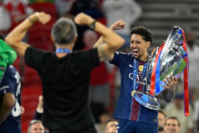 Paris Saint-Germain's Brazilian defender #05 Marquinhos (R) and Paris Saint-Germain's Spanish head coach Luis Enrique celebrate with the trophy after winning the UEFA Champions League final football match between Paris Saint-Germain (PSG) and Arsenal FC at the Puskas Arena in Budapest on May 30, 2026. (Photo by INA FASSBENDER / AFP)