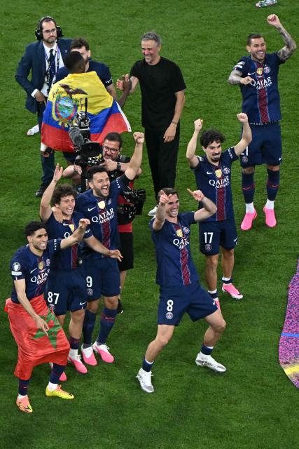 Paris Saint-Germain's Moroccan defender #02 Achraf Hakimi, Paris Saint-Germain's Portuguese midfielder #87 Joao Neves, Paris Saint-Germain's Portuguese forward #09 Goncalo Ramos, Paris Saint-Germain's Spanish head coach Luis Enrique, Paris Saint-Germain's Spanish midfielder #08 Fabian Ruiz, Paris Saint-Germain's Portuguese midfielder #17 Vitinha and Paris Saint-Germain's French defender #21 Lucas Hernandez celebrate after winning the UEFA Champions League final football match between Paris Saint-Germain (PSG) and Arsenal FC at the Puskas Arena in Budapest on May 30, 2026. (Photo by Attila KISBENEDEK / AFP)