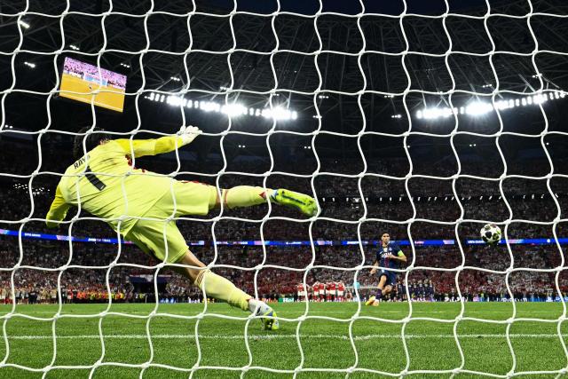 Paris Saint-Germain's Moroccan defender #02 Achraf Hakimi (R) scores a goal against Arsenal's Spanish goalkeeper #01 David Raya during a penalty shootout during the UEFA Champions League final football match between Paris Saint-Germain (PSG) and Arsenal FC at the Puskas Arena in Budapest on May 30, 2026. (Photo by Ina FASSBENDER / AFP)