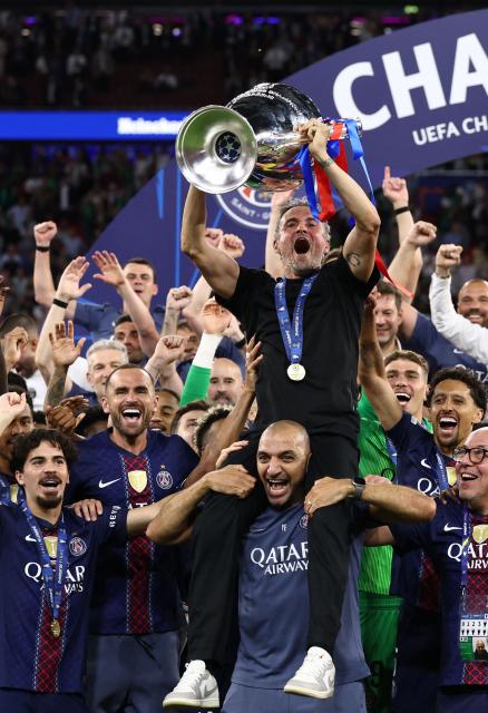 Paris Saint-Germain's Spanish head coach Luis Enrique lifts the trophy as he celebrates with his players after winning the UEFA Champions League final football match between Paris Saint-Germain (PSG) and Arsenal FC at the Puskas Arena in Budapest on May 30, 2026. (Photo by FRANCK FIFE / AFP)
