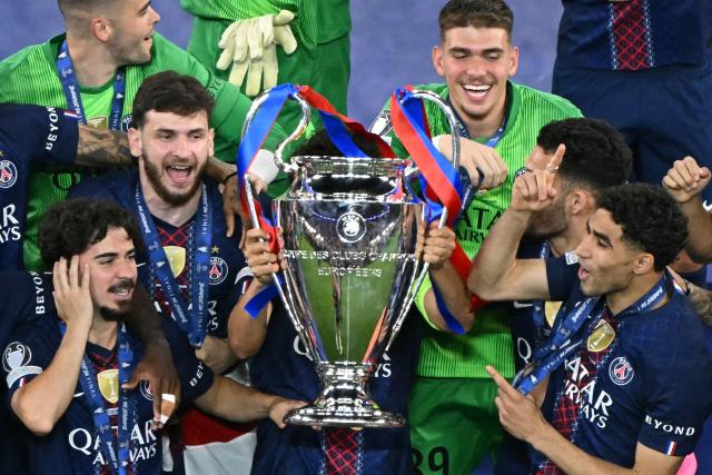 Paris Saint-Germain's Portuguese midfielder #17 Vitinha, Paris Saint-Germain's Georgian forward #07 Khvicha Kvaratskhelia, Paris Saint-Germain's Italian goalkeeper #89 Renato Marin and Morocco's defender #02 Achraf Hakimi celebrate with the trophy after winning the UEFA Champions League final football match between Paris Saint-Germain (PSG) and Arsenal FC at the Puskas Arena in Budapest on May 30, 2026. (Photo by Attila KISBENEDEK / AFP)