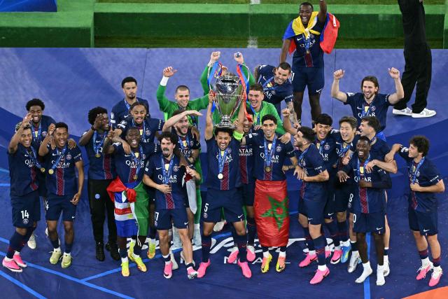 Paris Saint-Germain's Brazilian defender #05 Marquinhos lifts the trophy next to his teammates after winning the UEFA Champions League final football match between Paris Saint-Germain (PSG) and Arsenal FC at the Puskas Arena in Budapest on May 30, 2026. (Photo by Attila KISBENEDEK / AFP)