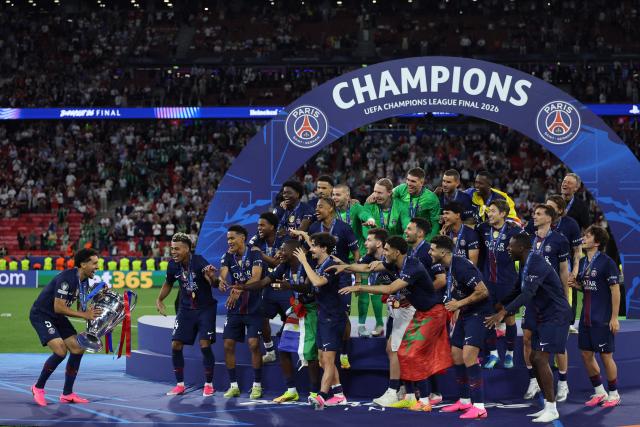 Paris Saint-Germain's Brazilian defender #05 Marquinhos (L) prepares to lift the trophy with teammates after winning the UEFA Champions League final football match between Paris Saint-Germain (PSG) and Arsenal FC at the Puskas Arena in Budapest on May 30, 2026. (Photo by FRANCK FIFE / AFP)