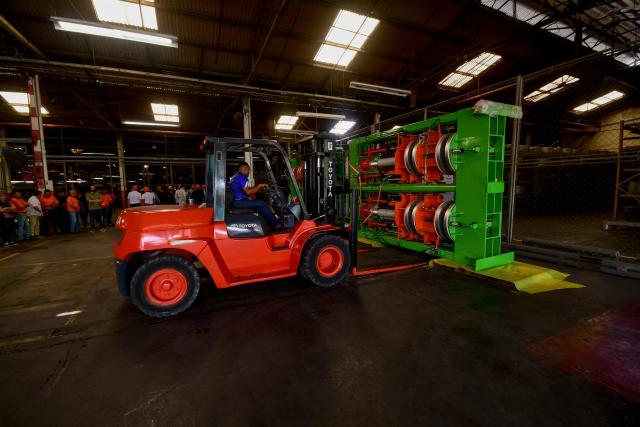 Workers move machinery for a new production line at the Caucho Industrial Park in Los Guayos municipality, Carabobo state, Venezuela, on May 30, 2026. After seven years of inactivity, the former Goodyear tyre plant was refurbished and resumed operations four months ago after the “Foreign Investment Fund,” including Brazilian, Chinese, and Bolivian investors, signed a contract with the Productive Investment Fund, an agency attached to the presidency of Venezuela. (Photo by Jacinto OLIVEROS / AFP)