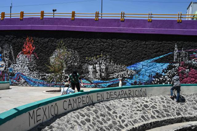 Members of collectives searching for missing persons affix missing-person flyers for their relatives while participating in a day of protest in front of Mexico City Stadium, which will host the opening ceremony of the upcoming FIFA World Cup, in Mexico City on May 30, 2026. (Photo by Yuri CORTEZ / AFP)