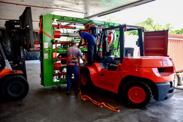 Workers move machinery for a new production line at the Caucho Industrial Park in Los Guayos municipality, Carabobo state, Venezuela, on May 30, 2026. After seven years of inactivity, the former Goodyear tyre plant was refurbished and resumed operations four months ago after the “Foreign Investment Fund,” including Brazilian, Chinese, and Bolivian investors, signed a contract with the Productive Investment Fund, an agency attached to the presidency of Venezuela. (Photo by Jacinto OLIVEROS / AFP)