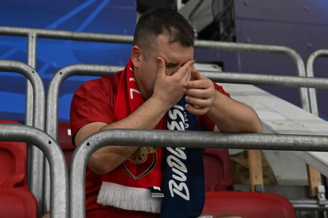 An Arsenal fan reacts after loosing the UEFA Champions League final football match between Paris Saint-Germain (PSG) and Arsenal FC at the Puskas Arena in Budapest on May 30, 2026. (Photo by Attila KISBENEDEK / AFP)
