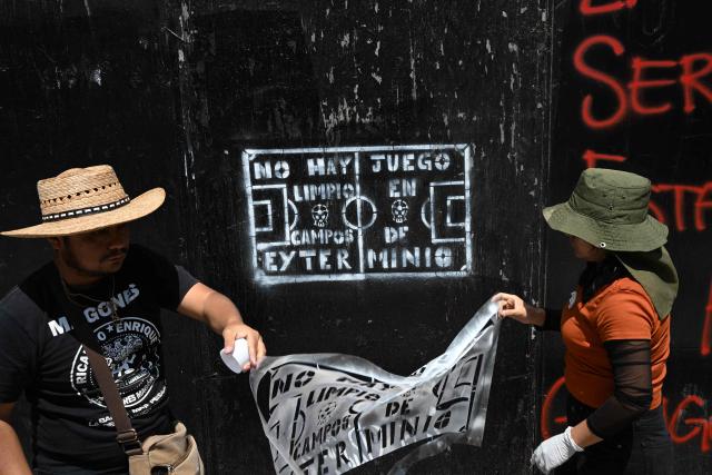 Members of collectives searching for missing persons affix missing-person flyers for their relatives while participating in a day of protest in front of Mexico City Stadium, which will host the opening ceremony of the upcoming FIFA World Cup, in Mexico City on May 30, 2026. (Photo by Yuri CORTEZ / AFP)