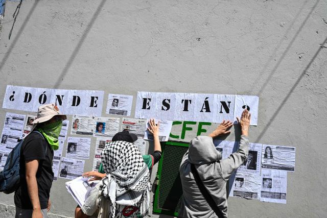 Members of collectives searching for missing persons affix search flyers featuring photos of their relatives while participating in a day of protest in front of Mexico City Stadium, which will host the opening ceremony of the upcoming FIFA World Cup, in Mexico City on May 30, 2026. (Photo by Yuri CORTEZ / AFP)
