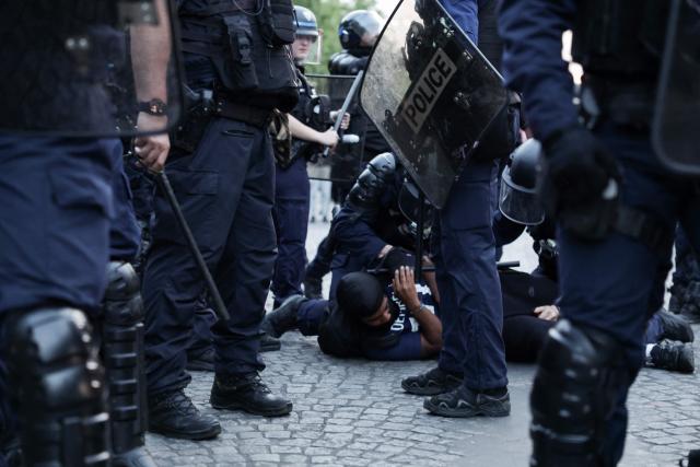 French Republican Security Corps (CRS - Compagnies Republicaines de Securite) Police officers detain a PSG supporter during celebrations following their team's win in the UEFA Champions League final between Paris Saint-Germain (PSG) and Arsenal FC played in Budapest, on the Champs-Elysees Avenue in Paris on may 30, 2026. (Photo by ROMEO BOETZLE / AFP)