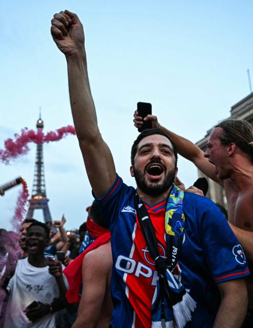 PSG supporters celebrate their team's win in the UEFA Champions League final between Paris Saint-Germain (PSG) and Arsenal FC played in Budapest, at Place du Trocadero opposite the Eiffel Tower in Paris on May 30, 2026. (Photo by LOU BENOIST / AFP)