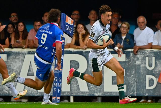 Pau's French wing Grégoire Arfeuil (R) runs to scores a try during the French Top14 rugby union match between Montpellier Herault Rugby and Section Paloise Bearn Pyrenees (Pau) at the GGL Stadium in Montpellier, southern France on May 30, 2026. (Photo by Sylvain THOMAS / AFP)
