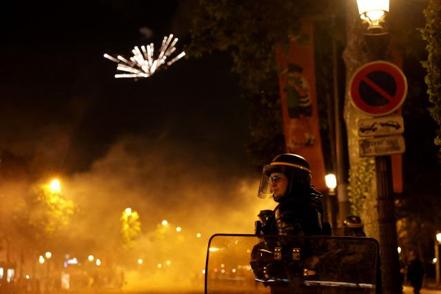A French Republican Security Corps (CRS - Compagnies Republicaines de Securite) Police officer stands guard during celebrations of PSG supporters after their team's win in the UEFA Champions League final between Paris Saint-Germain (PSG) and Arsenal FC played in Budapest, in Paris on may 30, 2026. (Photo by ROMEO BOETZLE / AFP)
