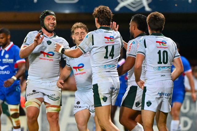 Pau's French wing Grégoire Arfeuil (C) is congratulated by his teammates after scoring a try during the French Top14 rugby union match between Montpellier Herault Rugby and Section Paloise Bearn Pyrenees (Pau) at the GGL Stadium in Montpellier, southern France on May 30, 2026. (Photo by Sylvain THOMAS / AFP)