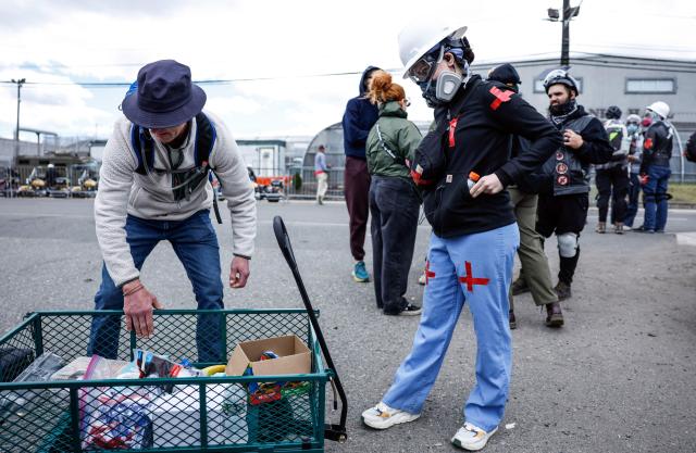 Protesters grab supplies while staging outside Delaney Hall, which is being used as an Immigration and Customs Enforcement (ICE) detention center, in Newark, New Jersey, on May 30, 2026. New Jersey state authorities announced on May 29 they were taking charge of security outside a US immigration detention center after clashes between ICE agents and protesters angered by conditions faced by detainees inside. Days of unrest have led to arrests as a tough stance by US President Donald Trump's administration on immigration policy continues to draws opposition, including from authorities in Democratic-led states. (Photo by kena betancur / AFP)