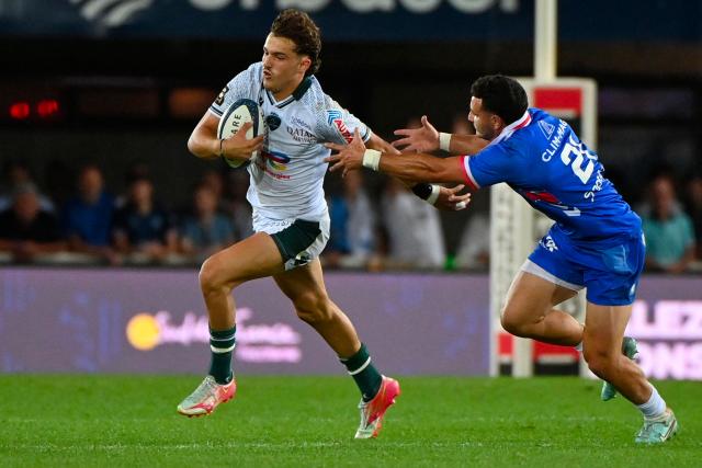 Pau's French wing Grégoire Arfeuil (L) runs with the ball during the French Top14 rugby union match between Montpellier Herault Rugby and Section Paloise Bearn Pyrenees (Pau) at the GGL Stadium in Montpellier, southern France on May 30, 2026. (Photo by Sylvain THOMAS / AFP)