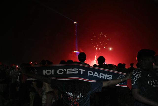 PSG supporters celebrate their team's win in the UEFA Champions League final between Paris Saint-Germain (PSG) and Arsenal FC played in Budapest, at Place du Trocadero opposite the Eiffel Tower in Paris on May 30, 2026. (Photo by LOU BENOIST / AFP)