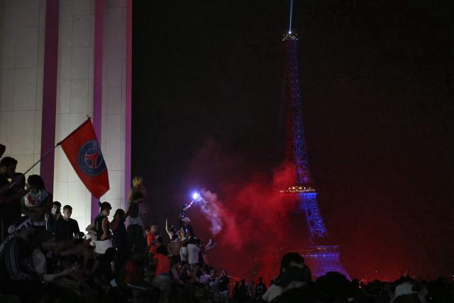 PSG supporters celebrate their team's win in the UEFA Champions League final between Paris Saint-Germain (PSG) and Arsenal FC played in Budapest, at Place du Trocadero opposite the Eiffel Tower in Paris on May 30, 2026. (Photo by LOU BENOIST / AFP)