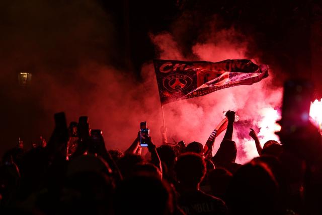 PSG supporters burn flares and wave a flag during gatherings after PSG won the UEFA Champions League final between Paris Saint-Germain (PSG) and Arsenal FC played in Budapest, in Paris on May 30, 2026. (Photo by ROMEO BOETZLE / AFP)