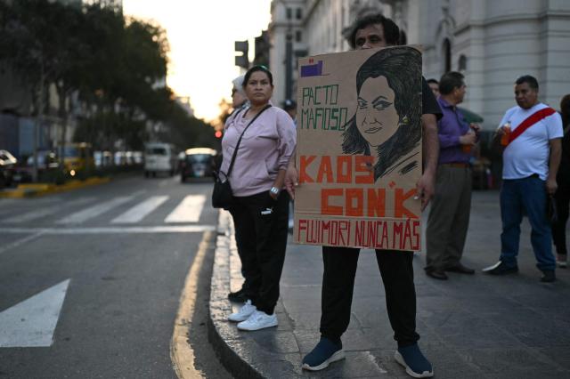 A man holds a banner with a drawing of right-wing candidate Keiko Fujimori before a march against her in Lima on May 30, 2026. Right-wing candidate Keiko Fujimori and left-wing candidate Roberto Sanchez will face off on June 7 in Peru's presidential runoff, the electoral authority confirmed on May 17 when it officially proclaimed the results. (Photo by ERNESTO BENAVIDES / AFP)