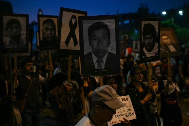 People hold photos of victims of violence from the government of Peru’s former president (1990–2000) Alberto Fujimori during a march against right-wing candidate Keiko Fujimori in Lima on May 30, 2026. Right-wing candidate Keiko Fujimori and left-wing candidate Roberto Sanchez will face off on June 7 in Peru's presidential runoff, the electoral authority confirmed on May 17 when it officially proclaimed the results. (Photo by ERNESTO BENAVIDES / AFP)