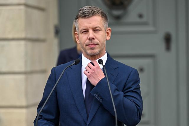 Hungary’s Prime Minister Peter Magyar adjusts his tie during a door-step presser after a meeting with Hungary's President at the presidential office in Sandor-palace, Budapest, Hungary, on June 1, 2026. The meeting takes place a day after a deadline set out by Magyar for the resignation of Sulyok has passed. The prime minister has urged top state officials, whom he called puppets of his predecessor, to step down by the end of May or face removal from office. (Photo by Attila KISBENEDEK / AFP)