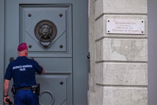 An officer opens the door as a plaque on the wall reads 'Sandor-Palota (Sandor-palace) Office of the President of Hungary' in Budapest, Hungary, on June 1, 2026. The meeting takes place a day after a deadline set out by Magyar for the resignation of Sulyok has passed. The prime minister has urged top state officials, whom he called puppets of his predecessor, to step down by the end of May or face removal from office. (Photo by Attila KISBENEDEK / AFP)