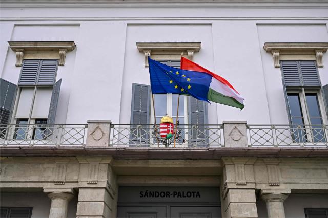 EU flag and Hungarian national flag wave on balcony of the presidential office as the inscription on top of the door reads 'Sandor-Palota (Sandor-palace)' in Budapest, Hungary, on June 1, 2026. The meeting takes place a day after a deadline set out by Magyar for the resignation of Sulyok has passed. The prime minister has urged top state officials, whom he called puppets of his predecessor, to step down by the end of May or face removal from office. (Photo by Attila KISBENEDEK / AFP)