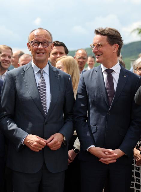 German Chancellor and leader of Germany's Christian Democratic Union (CDU) Friedrich Merz (L) and North Rhine-Westphalia's State Premier and leader of the state's CDU Hendrik Wuest speak as they gather with other participants for a group photo in Meschede, western Germany, on June 1, 2026, during a two-day party meeting to prepare for the 2027 North Rhine-Westphalia state elections. (Photo by Oliver Berg / POOL / AFP)