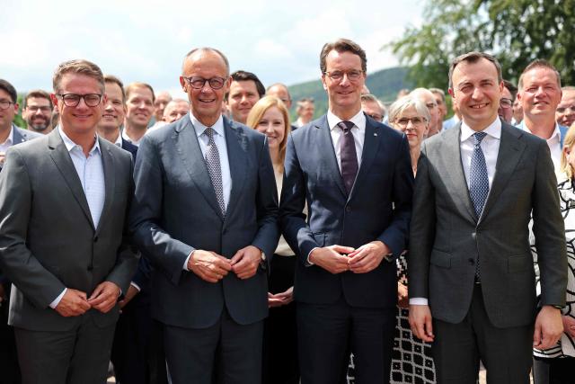 (LtoR) Secretary General of Germany's Christian Democratic Union (CDU) Carsten Linnemann, German Chancellor and CDU leader Friedrich Merz and North Rhine-Westphalia's State Premier and leader of the state's CDU Hendrik Wuest, and NRW's CDU Secretary General Paul Ziemiak and other participants gather for a group photo in Meschede, western Germany, on June 1, 2026, during a two-day party meeting to prepare for the 2027 North Rhine-Westphalia state elections. (Photo by Oliver Berg / POOL / AFP)