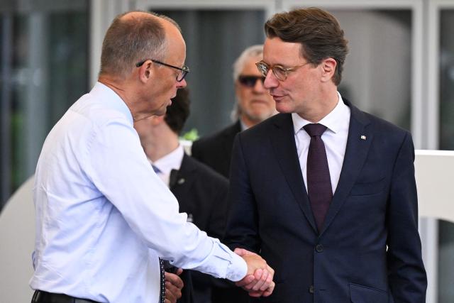 State premier of North Rhine-Westphalia Hendrik Wuest (R) and German Chancellor and Chairman of Germany's conservative Christian Democratic Union (CDU) party Friedrich Merz shake hands after a party meeting to prepare for the 2027 North Rhine-Westphalia's state elections in Meschede, western Germany, on June 1, 2026. (Photo by INA FASSBENDER / AFP)