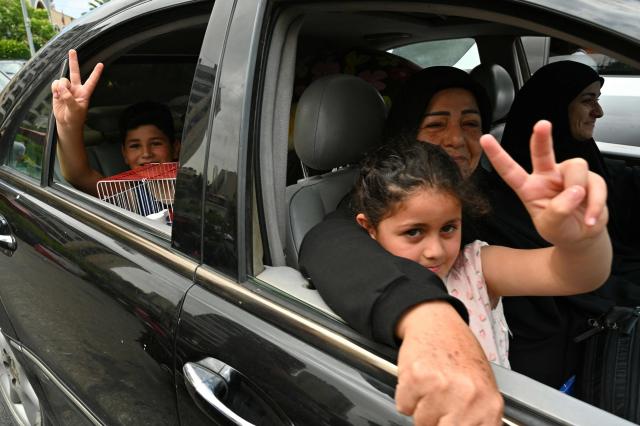 Children make victory signs as their family flees their home after Israel ordered attacks on the southern suburbs of Lebanon's capital Beirut on June 1, 2026. Israel's defence minister said on June 1 there would be "no calm in Beirut" if Hezbollah attacks continued and vowed to establish a military-controlled zone in the area of south Lebanon's Litani River. (Photo by FADEL itani / AFP)