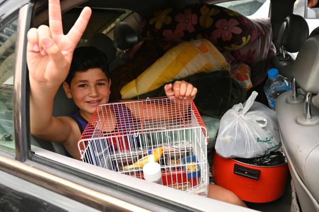 A boy makes a victory sign from the backseat of a car loaded with belongings as residents flee their homes after Israel ordered attacks on the southern suburbs of Lebanon's capital Beirut on June 1, 2026. Israel's defence minister said on June 1 there would be "no calm in Beirut" if Hezbollah attacks continued and vowed to establish a military-controlled zone in the area of south Lebanon's Litani River. (Photo by FADEL itani / AFP)