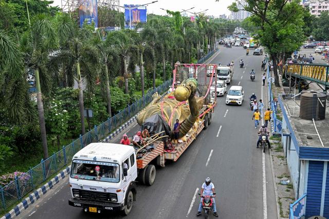 Workers transport a statue of Argentine football player Lionel Messi after its removal for re-installation to a safer place in Kolkata on June 1, 2026. A giant statue of football superstar Lionel Messi erected in India to mark his visit last year is "swaying in the wind" and will be removed, a lawmaker told AFP on May 27. (Photo by Dibyangshu SARKAR / AFP)