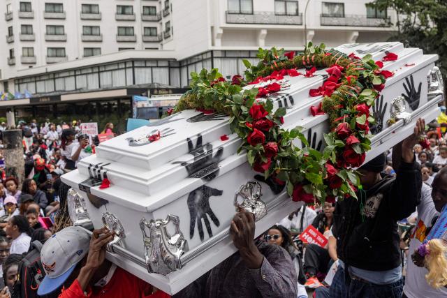 Protesters carry an empty coffin as they stage a sit in during a protest against an alarming rise in femicide cases, in Nairobi on June 1, 2026. (Photo by SIMON MAINA / AFP)