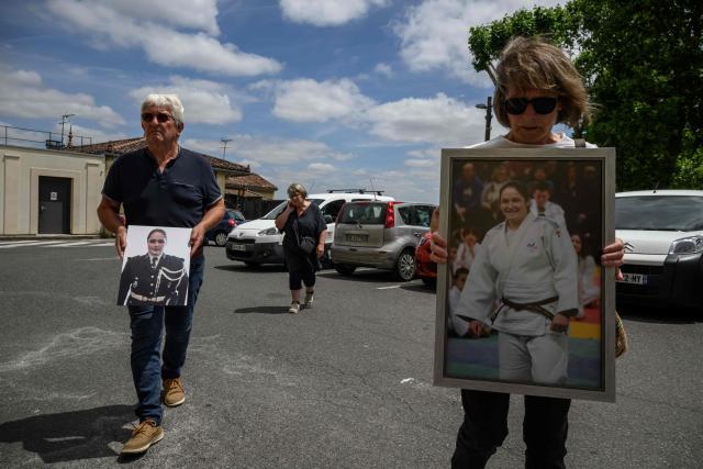 The parents of late French gendarme Melanie Lemee hold portraits of their daughter as they arrive at the Gers' Assize Court, in Auch on June 1, 2026 to attend the appeal trial of Yassine El Azizi, who fatally struck the gendarme in 2020. Yassine El Azizi, a 31-year-old drug trafficker is standing trial on appeal before the Gers Assize Court for killing a gendarme officer whilst forcing his way through a roadblock; he was driving without a licence and under the influence of drugs. At first instance, the defendant had been sentenced to 30 years imprisonment by the Lot-et-Garonne Assize Court. Throughout the trial, he had denied deliberately ramming into the victim. (Photo by Ed JONES / AFP)
