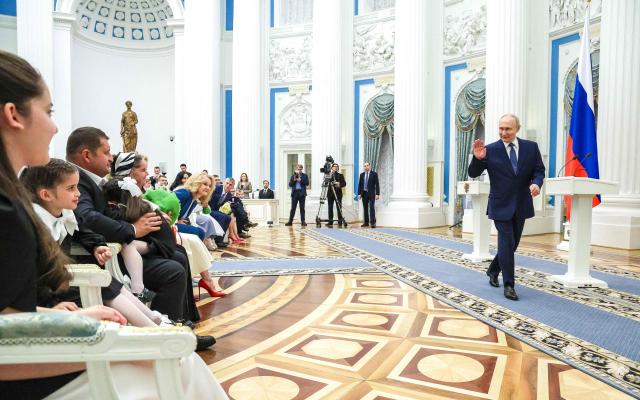 In this pool photograph distributed by the Russian state agency Sputnik, Russia's President Vladimir Putin gestures during a ceremony to present awards to families with three or more children at the Kremlin in Moscow on June 1, 2026, International Children's Day. (Photo by Vyacheslav PROKOFYEV / POOL / AFP)