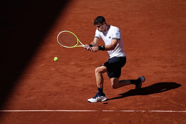 Argentina's Juan Manuel Cerundolo plays a backhand return to Italy's Matteo Berrettini during their men's singles match on day 9 of the French Open tennis tournament on Court Suzanne-Lenglen at the Roland-Garros Complex in Paris on June 1, 2026. (Photo by Anne-Christine POUJOULAT / AFP)