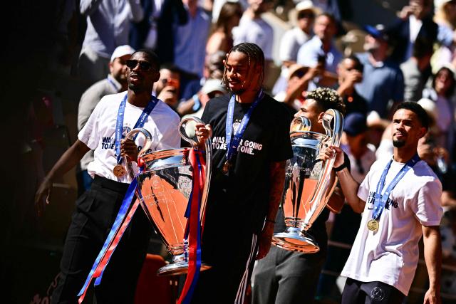 (Frm L) Paris Saint-Germain's French forward #10 Ousmane Dembele, Paris Saint-Germain's French forward #29 Bradley Barcola, Paris Saint-Germain's French midfielder #14 Desire Doue and Paris Saint-Germain's French midfielder #33 Warren Zaire-Emery bring the two UEFA Champions League's trophies on day 9 of the French Open tennis tournament on Court Philippe-Chatrier at the Roland-Garros Complex in Paris on June 1, 2026. Paris Saint-Germain (PSG) claimed back-to-back Champions League triumphs with a 4-3 shoot-out win over Arsenal following a 1-1 draw after extra time at the Puskas Arena in Budapest on May 30, 2026. (Photo by JULIEN DE ROSA / AFP)