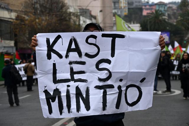 A protester holds a placard reading "Kast lied to you" during a protest march against President Jose Antonio Kast's State of the Nation address in Valparaiso, Chile, on June 1, 2026. (Photo by RODRIGO ARANGUA / AFP)