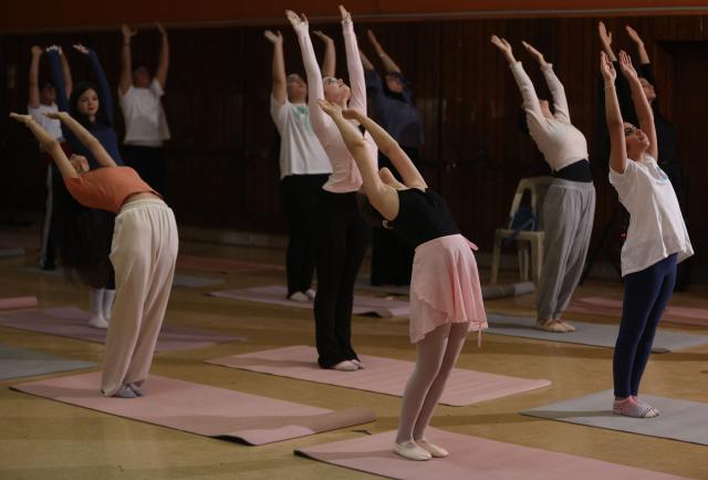 Iraqi girls practise yoga at a dance and ballet school in the Mansour district of Baghdad on June 1, 2026, preparation for International Day of Yoga. (Photo by AHMAD AL-RUBAYE / AFP)